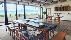 Un comedor moderno con una mesa larga, sillas y diversos equipos para té y café.