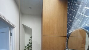 A modern bathroom with a white toilet, a sink with a mirror, and a shower area.