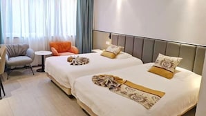 A hotel room with two beds, a small table, a chair, and a view of the outdoors. - Hengdian World Studios Resort (Dongyang)