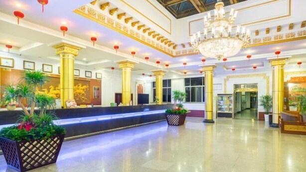 A spacious lobby with a reception desk, large columns, and a chandelier. - Hengdian World Studios Resort (Dongyang)