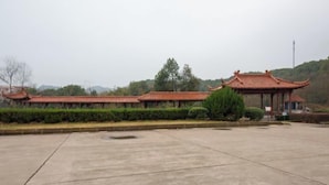 A traditional Chinese building with a tiled roof and a pavilion. - Hengdian World Studios Resort (Dongyang)