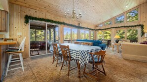 A wooden interior with a dining area, a sofa, and a chandelier. - Lakefront Escape, On Snowmobile Trail, Near Town (Old Forge)