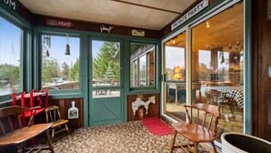 A cozy room with a large window, a wooden table, and chairs. There is a sign indicating a private party area. - Lakefront Escape, On Snowmobile Trail, Near Town (Old Forge)
