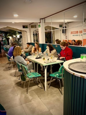 Ein Restaurantinneres mit Tischen, Stühlen und einer Theke.