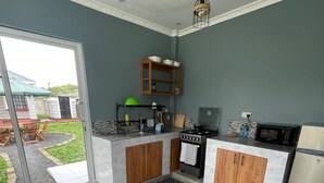 Une cuisine moderne équipée d’une cuisinière à gaz, d’un four à micro-ondes et de meubles de rangement en bois.