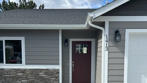 A residential house with a stone foundation, a red door, and a garage door. - Brand New Luxury Townhouse Getaway in Lewiston, Idaho!   (Lewiston)