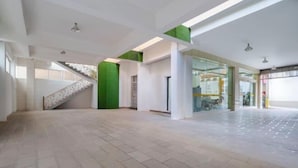Un intérieur spacieux avec un escalier, un mur en verre et un sol carrelé.