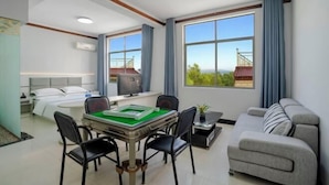 Une chambre d’hôtel avec un lit, un bureau équipé d’un ordinateur, un canapé et une vue sur l’extérieur.