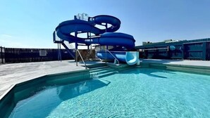 Ein klares, blaues Schwimmbecken mit einer Wasserrutsche.