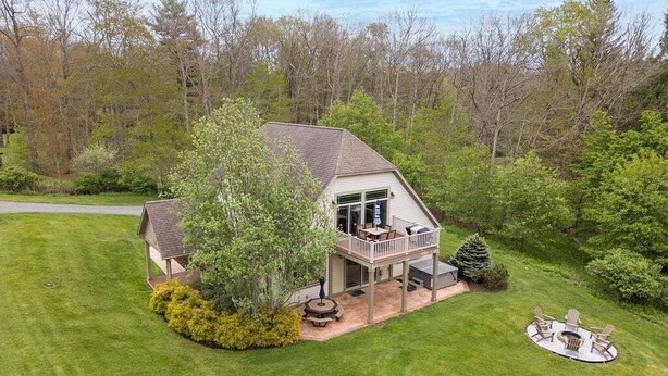 A house with a deck, a patio, and a circular seating area.