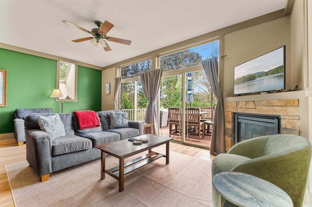 A living room with a sofa, coffee table, and a fireplace.