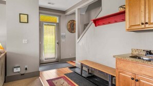 A kitchen with wooden cabinets, a granite countertop, and a red shelf.