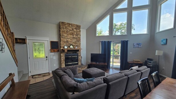 A spacious living room with a large sectional sofa, a fireplace, a TV, and a dining area with a wooden table and chairs. - Family Mountain Escape w/ Hot Tub & Game Room (Oakland)