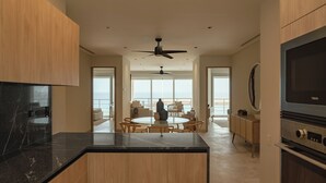 Een moderne keuken met een centraal kookeiland, houten kastjes en een grote televisie.