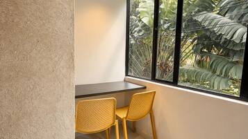 A room with a window, a table, and two chairs.