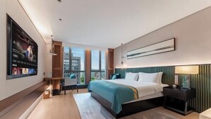 A modern hotel room with a large bed, a TV, a desk, and a view of the city. - Meridian Hotel (Chongqing)