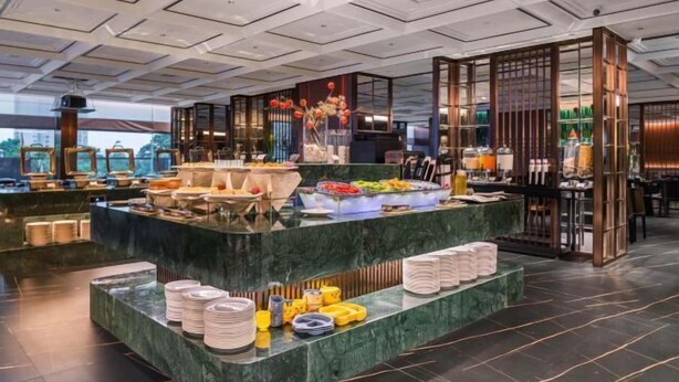 A buffet area with a marble counter, various food items, and a decorative centerpiece. - Meridian Hotel (Chongqing)