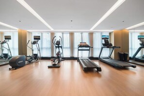 A gym with treadmills, elliptical machines, and a rowing machine. - Meridian Hotel (Chongqing)