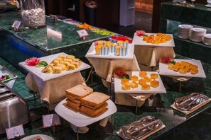 A buffet with various food items and utensils. - Meridian Hotel (Chongqing)