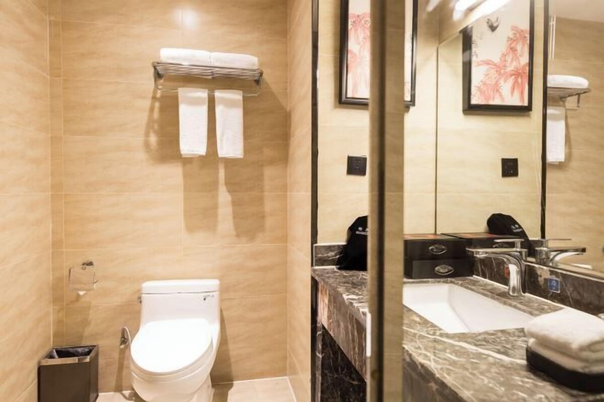 Un baño moderno con inodoro, lavamanos y encimera de mármol.