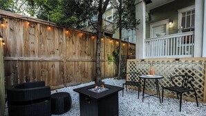 Un'area patio con un braciere, posti a sedere all'aperto e una recinzione in legno.