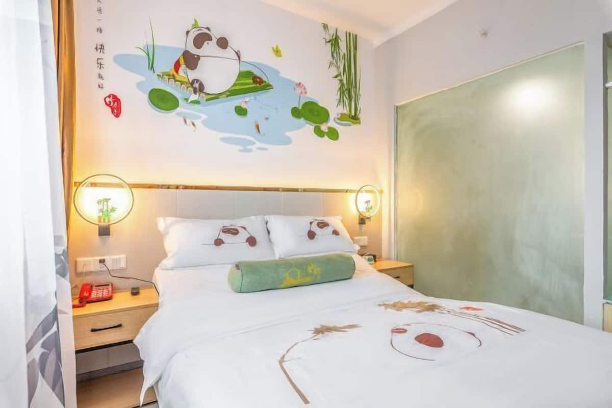 Una habitación de hotel con una cama, mesitas de noche, un mural en la pared y un armario.