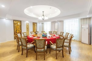 Un comedor con una mesa redonda, sillas y una araña.