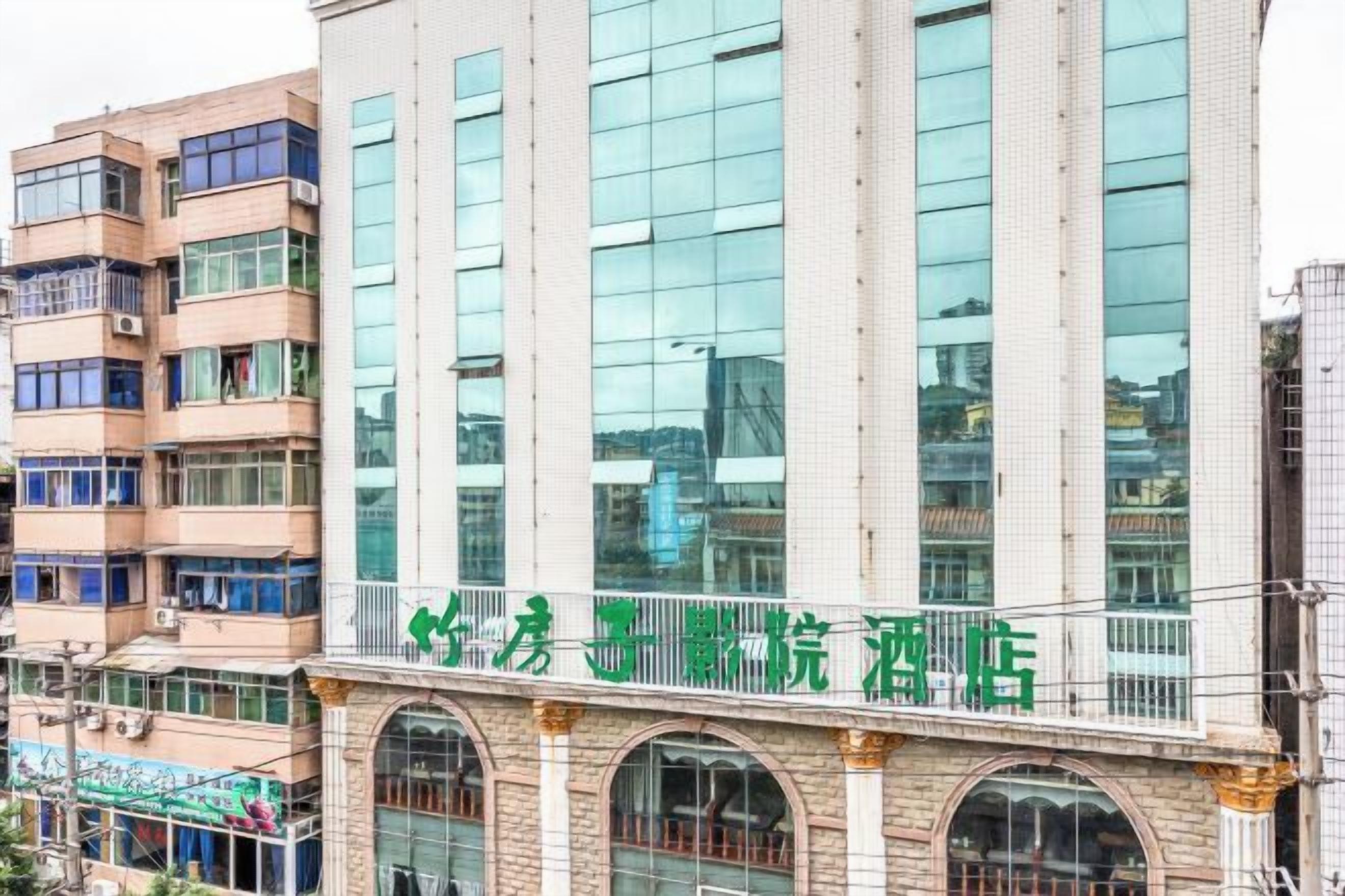 A multi-story building with a prominent green sign on the ground floor.