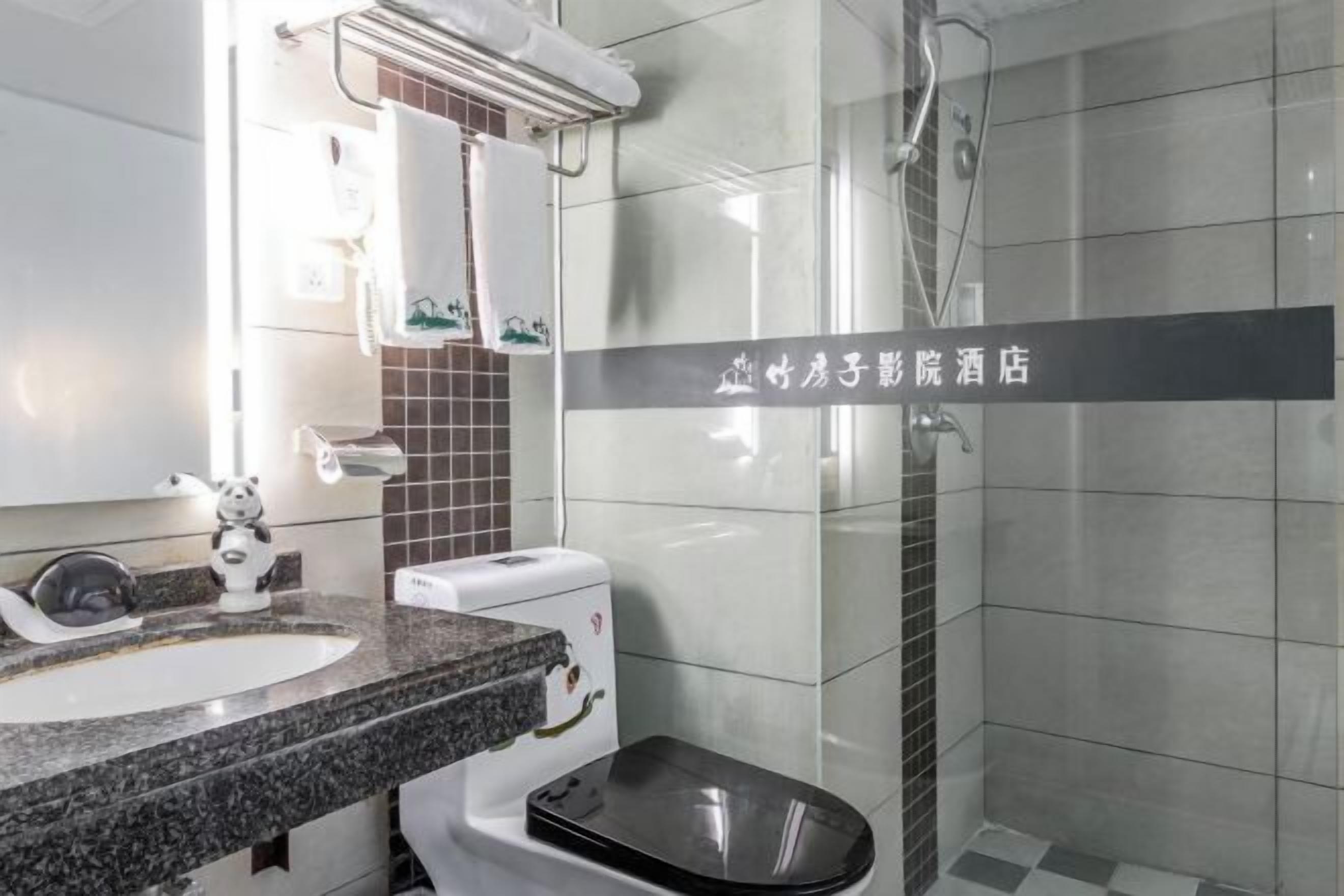 Un baño moderno con lavamanos de granito, inodoro y cabina de ducha de vidrio.