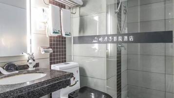 Un baño moderno con lavamanos de granito, inodoro y cabina de ducha de vidrio.