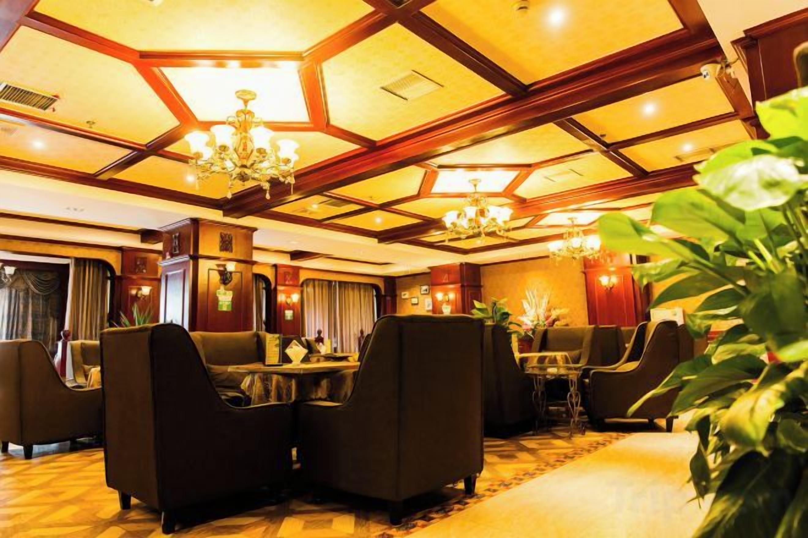 A hotel lobby with a high ceiling, chandeliers, and comfortable seating areas.