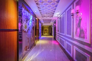 A corridor with a patterned ceiling, decorative wall panels, and a marble floor. - Zhufangzi Cinema Hotel (Anyue Beimenkou) (Anyue)
