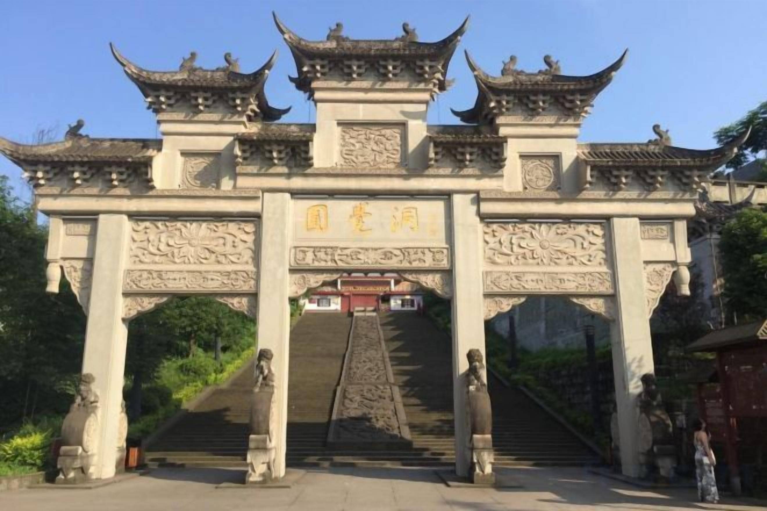 A traditional Chinese gate with intricate carvings and a staircase leading up to it.