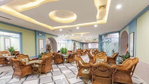 Eine geräumige Lobby mit Korbmöbeln und Fliesenboden, mit modernem Deckenstil und großen Fenstern.