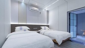 A modern hotel room with two beds, a built-in air conditioning unit, and a glass door leading to a balcony. - Xiaoxi Hostel (Zhangjiajie)