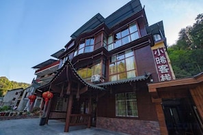 A traditional building with a wooden facade, large windows, and a sign with Chinese characters.