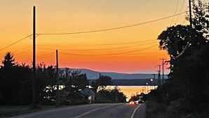 Una carretera con un atardecer al fondo.