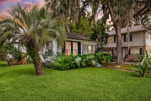 A residential property with a well-maintained lawn, a palm tree, and a house with a number '48' sign.