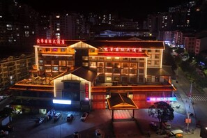 A multi-story hotel with a prominent entrance and a parking area. - Longji International Hotel (Longsheng)
