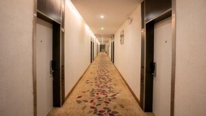 A hotel hallway with a carpeted floor and doors on both sides. - Kaili Shangjie Hotel (International Trade Shopping Center) (Kaili)
