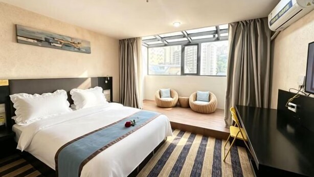A hotel room with a bed, a desk, a chair, a TV, and a window with curtains. - Kaili Shangjie Hotel (International Trade Shopping Center) (Kaili)