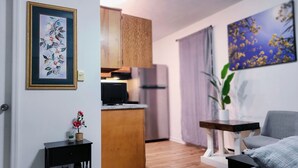Un espace de vie compact comprenant une kitchenette, un coin repas et un salon.