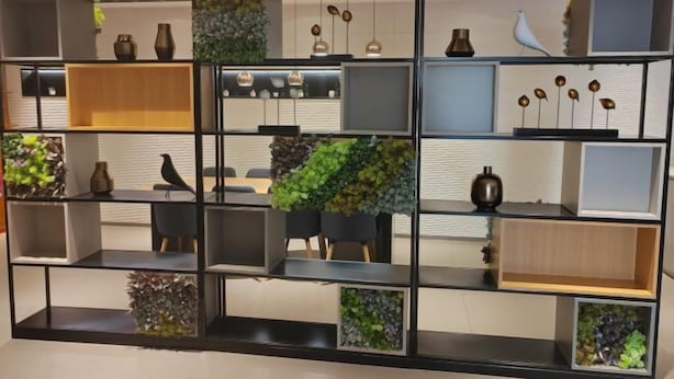 A modern interior with a black metal shelving unit displaying various decorative items and plants. - Homeinn Pebble Hotel (Linyi Yinan Government Plaza) (Yinan)