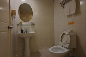 A small, clean bathroom with a toilet, sink, and mirror. There is a towel rack above the toilet and a sign on the wall. - Homeinn Pebble Hotel (Linyi Yinan Government Plaza) (Yinan)
