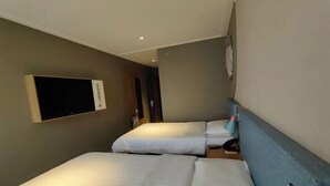 A hotel room with two beds, a flat-screen TV mounted on the wall, and a small table with a chair. - Homeinn Pebble Hotel (Linyi Yinan Government Plaza) (Yinan)
