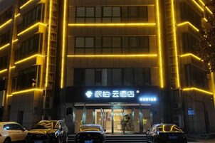 A hotel entrance with illuminated signage and a modern facade.