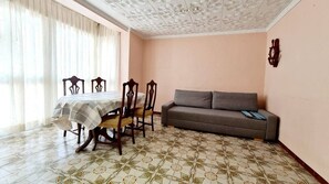 Enjoy meals in the dining area with a table and chairs, surrounded by a patterned floor and decorative ceiling.