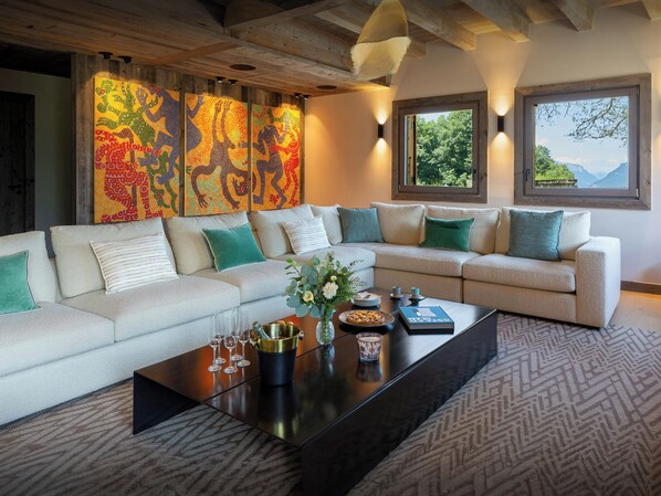A modern living room with a sectional sofa, decorative wall art, and a coffee table with glasses and a book.