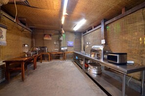 A kitchen with a brick ceiling, stainless steel appliances, and a long counter. - Xishuangbanna Peacock Princess Hotel (Jinghong)