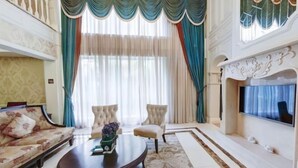 A spacious living room with a sofa, armchairs, a coffee table, and a fireplace. - Chengdu Star Flower Garden Hotel (University Games Sports Center) (Chengdu)